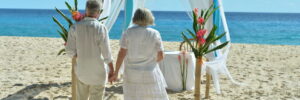 Beautiful happy elderly couple renewing their vows on the beach